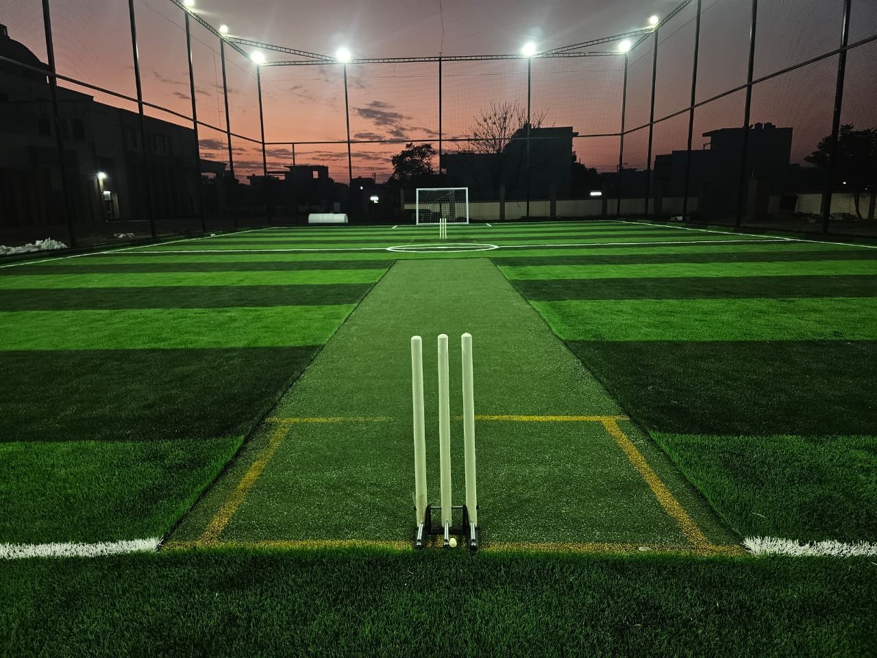 Floodlit cricket turf at dusk